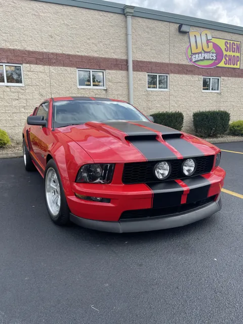 Racing stripes on a red Mustang
